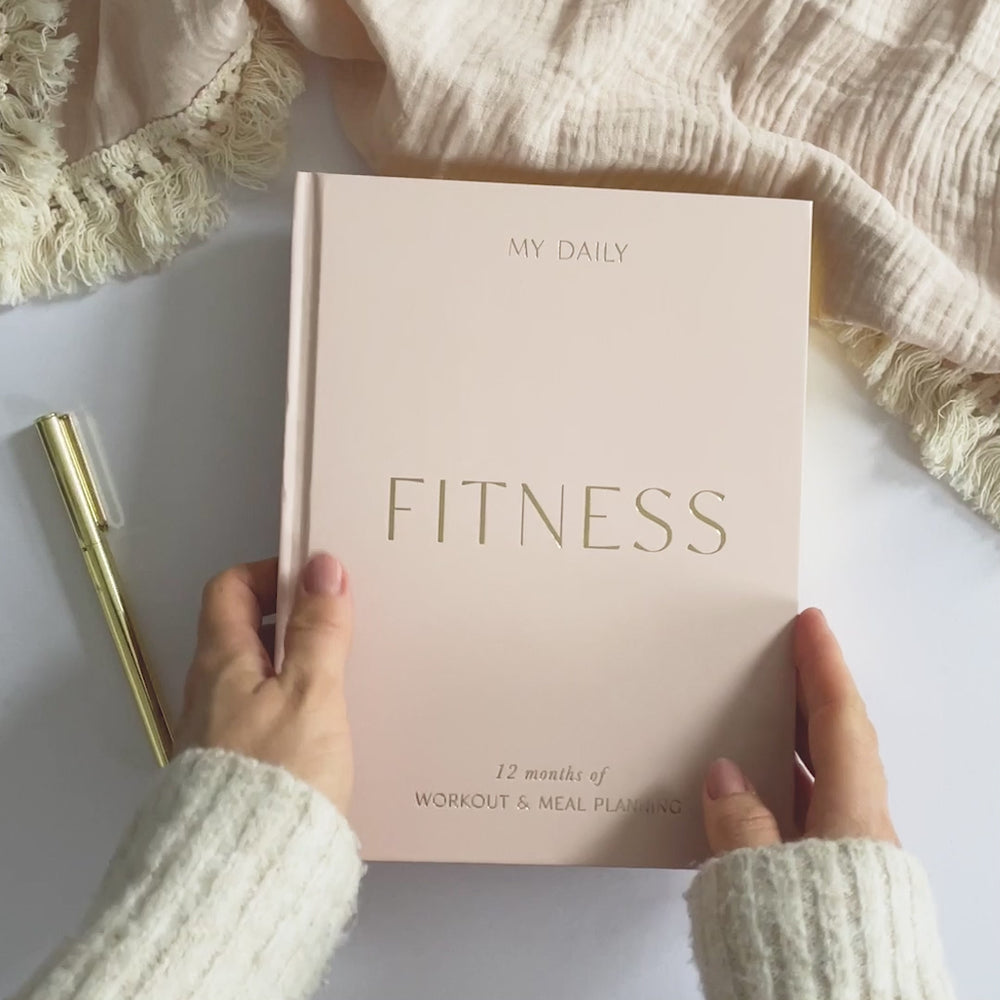 Fitness Log Book placed next to a water bottle on a gym bench.