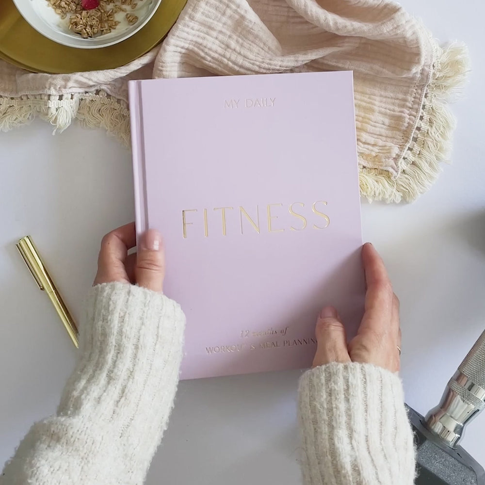 Flat lay of fitness journal with workout gear and trainers