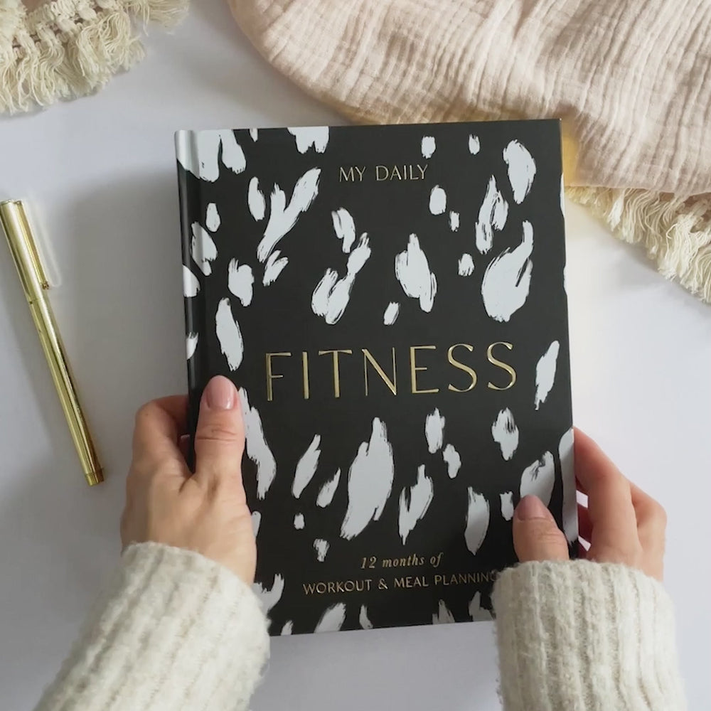 Exercise log and nutrition tracker open on wooden desk