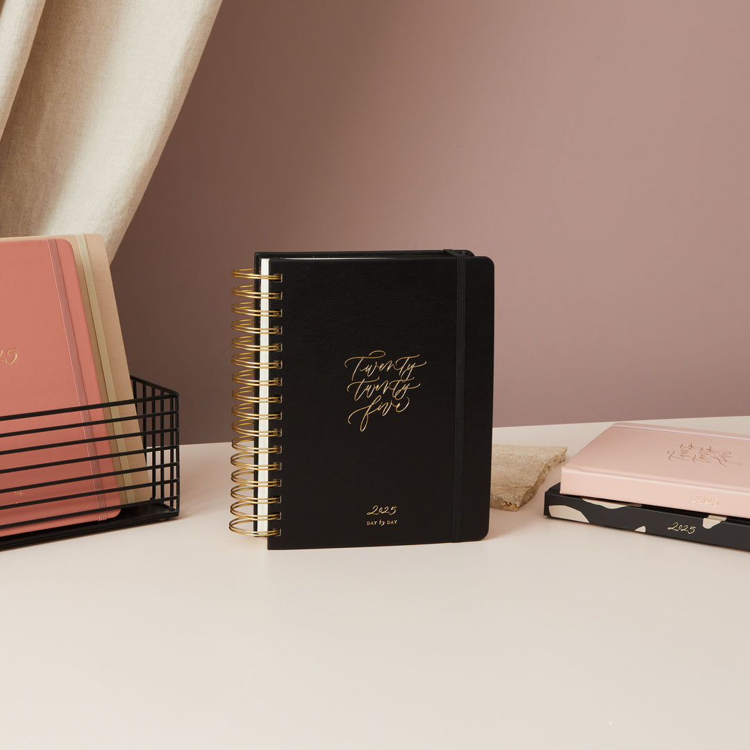 2025 daily diary with a chic black vegan leather cover and gold foil details, offering a blend of functionality and beauty.