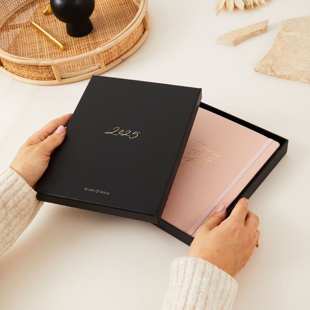 Soft pink vegan leather 2025 weekly planner with gold details, designed with time-blocking for each day, to-do lists, note space, and sections for monthly goals and budgeting.