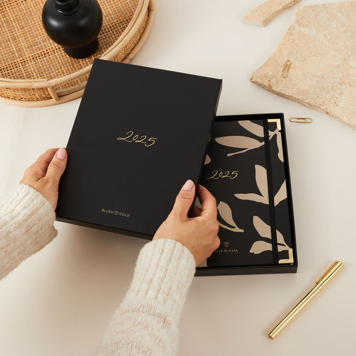 2025 planner with minimalist floral details and gold foil accents, featuring a weekly time-blocking layout, to-do lists, and sections for monthly goals and budgeting.
