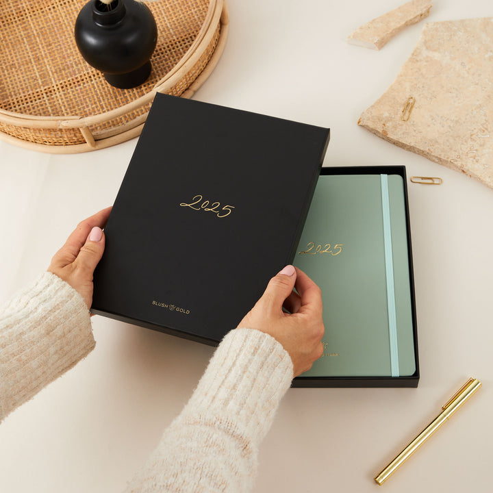 Elegant 2025 weekly planner with a sage green vegan leather cover and gold details, including time-blocking for each day, to-do lists, and monthly goal and budget pages.