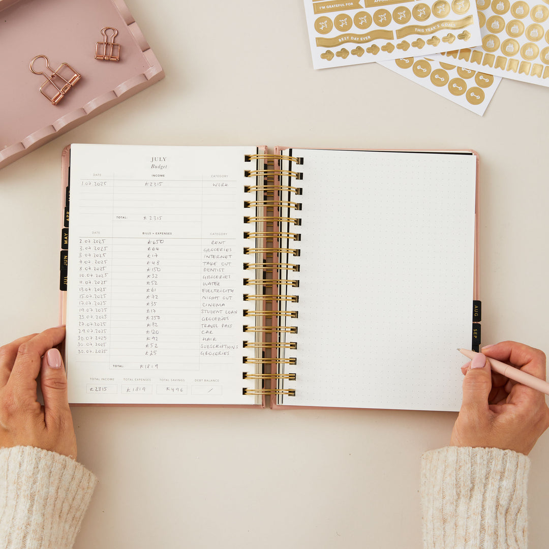 2025 planner with a pink cover, offering day-to-view pages with dedicated sections for today's priorities, a time-blocked schedule, to-do list, and meal planning.