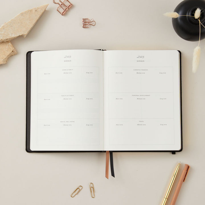 2025 planner in soft black vegan leather with gold details, offering equal space for daily time-blocking, to-do lists, and sections for monthly goals and budget tracking.