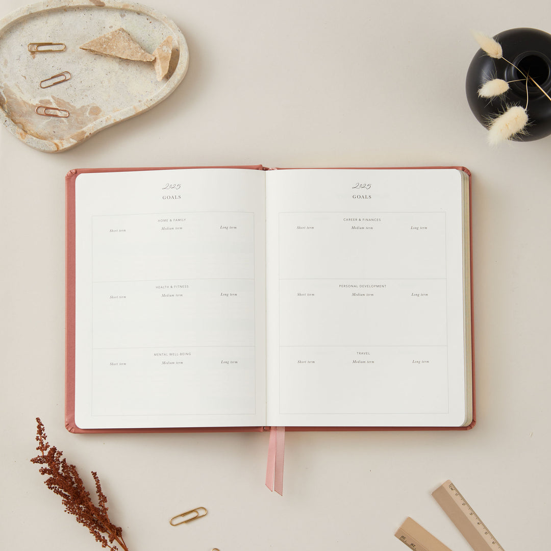 2025 weekly planner with a clay vegan leather cover and gold details, designed with equal space for time-blocking each day, to-do lists, notes, and monthly budgeting.