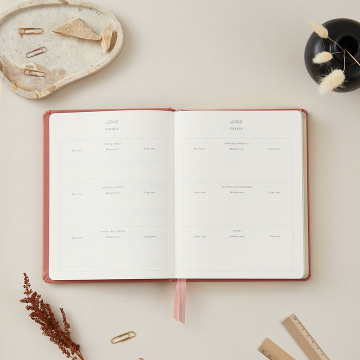 2025 weekly planner with a clay vegan leather cover and gold details, designed with equal space for time-blocking each day, to-do lists, notes, and monthly budgeting.