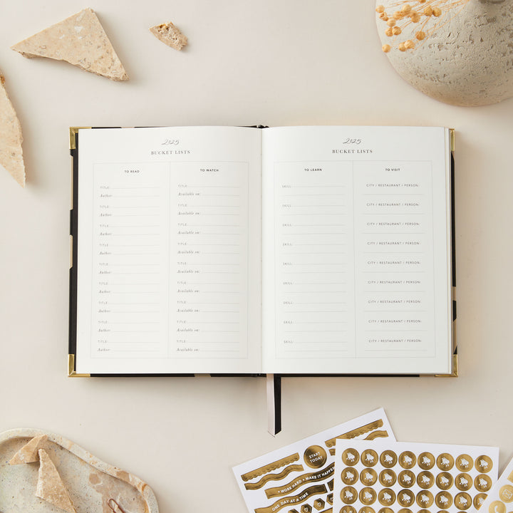 2025 weekly planner featuring a minimalist floral design, gold foil cover, and gold edging, complete with time-blocking, to-do lists, notes, and budget pages.