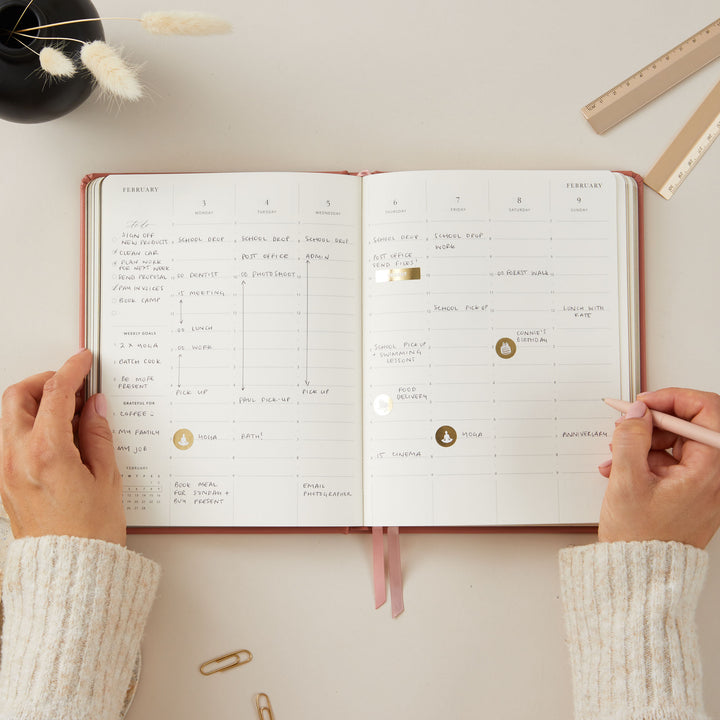 2025 weekly planner with a chic clay vegan leather cover and gold details, providing daily time-blocking, to-do lists, and sections for notes, monthly goals, and budget planning.