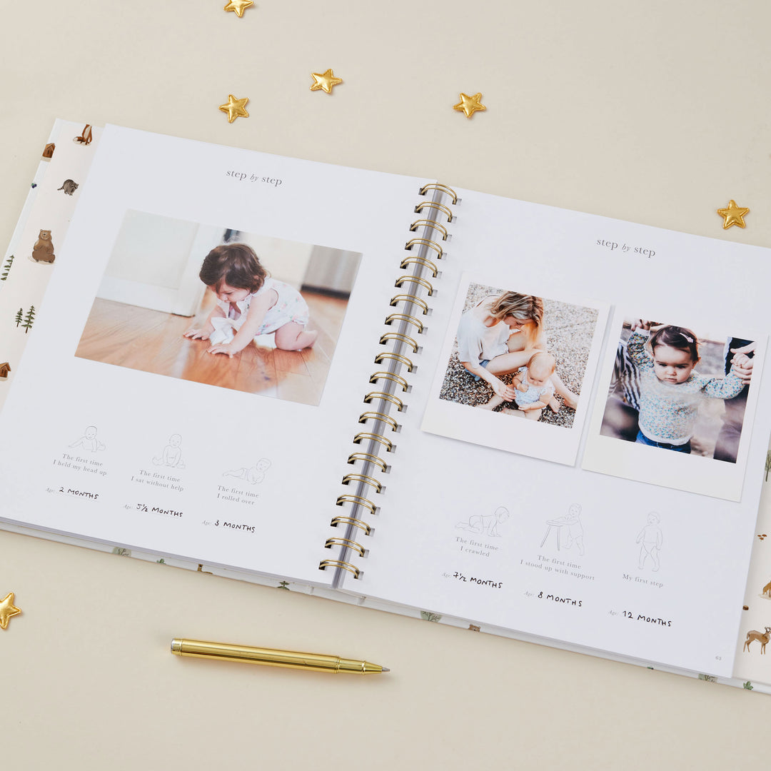 Open photo album with baby milestone photos on a beige background