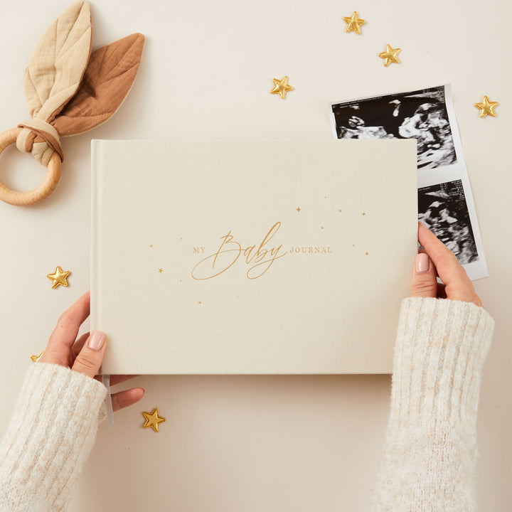 Cover of a baby memory book with a cute stars pattern in gold foil