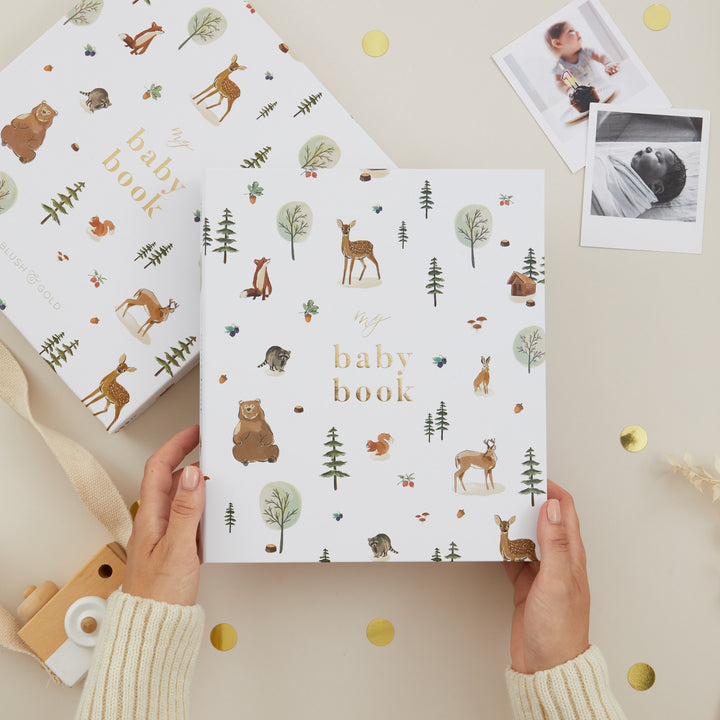 Woodland baby memory book with animal illustrations and gold foil cover.