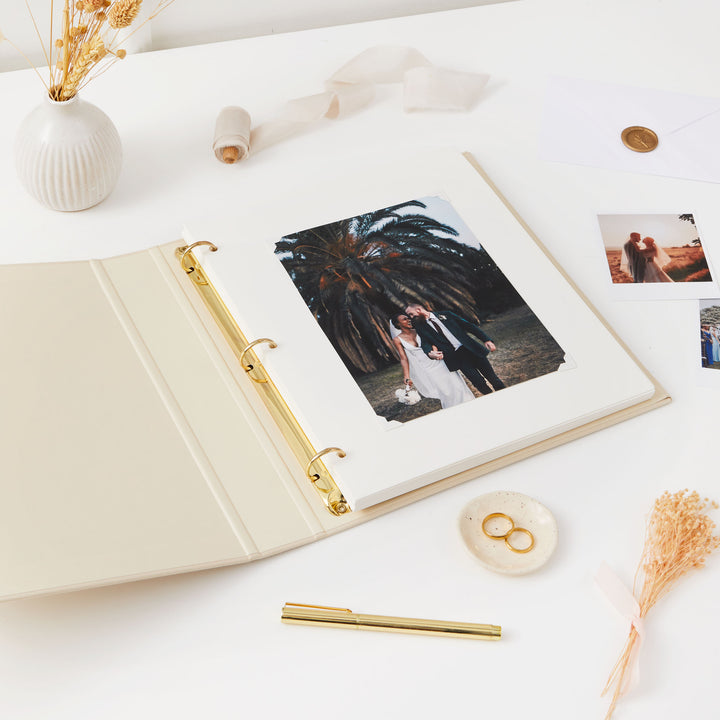 Beautiful blank wedding photo album featuring a soft ivory cloth cover, gold details, and a protective slipcase.