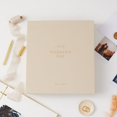 Elegant blank wedding photo album with a cloth ivory cover, gold details, and a matching slipcase, perfect for newlyweds.