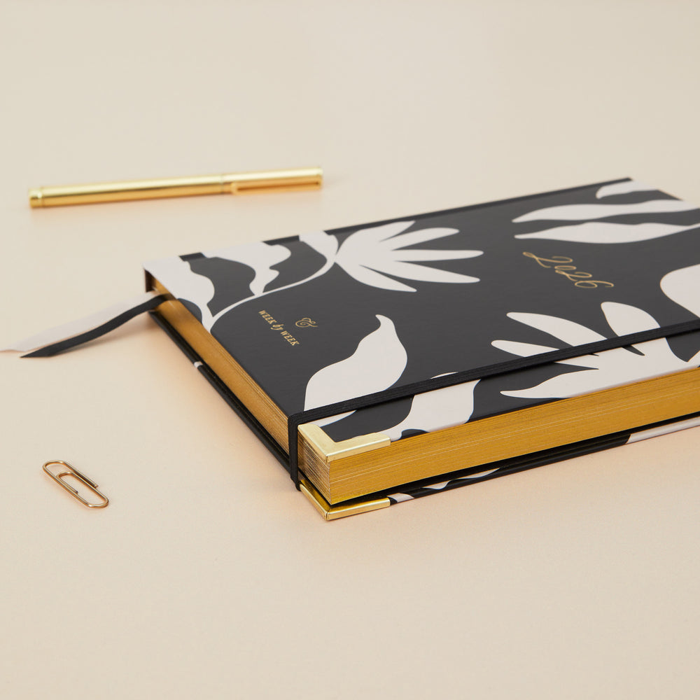 Diary with black and white floral design on a beige background