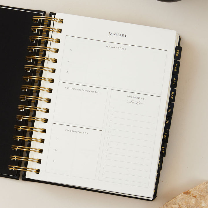 Elegant black vegan leather 2025 daily diary with eye-catching gold foil details, designed for a stylish and practical planning experience.