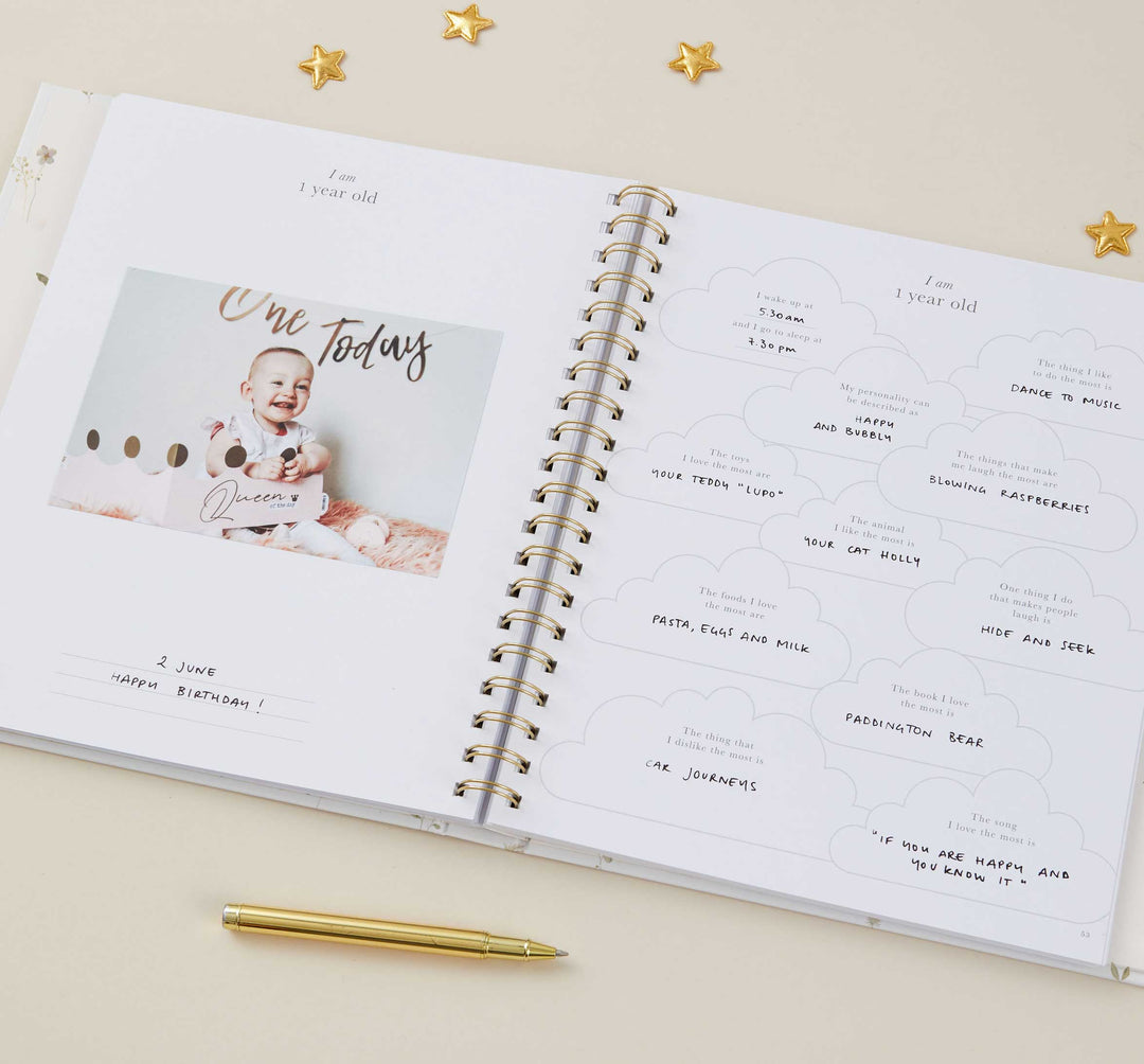 Open spiral-bound book with a photo of a baby and text on a beige background