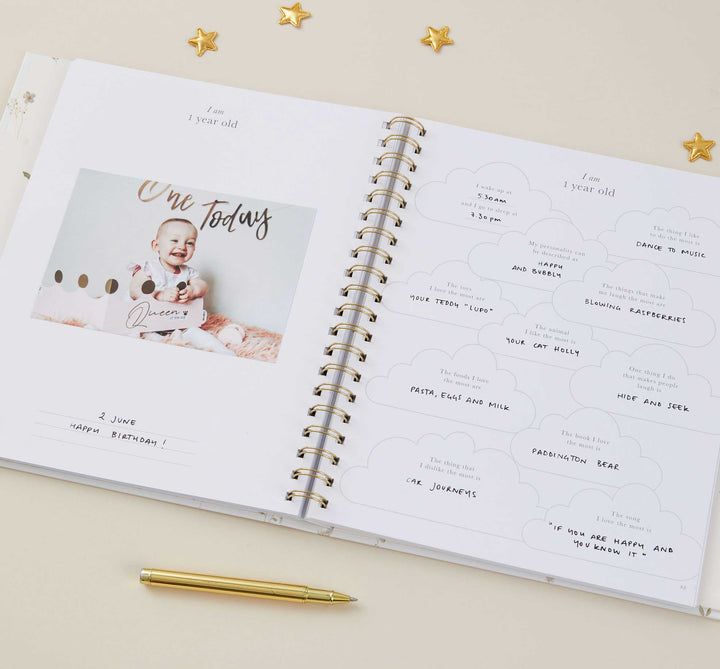 Open spiral-bound book with a photo of a baby and text on a beige background