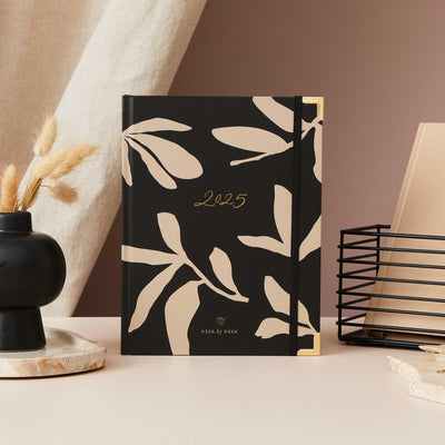 2025 weekly planner with a minimalist floral design, featuring a gold foil cover and gold edging, with week-to-view pages, time blocking, to-do lists, and space for notes.