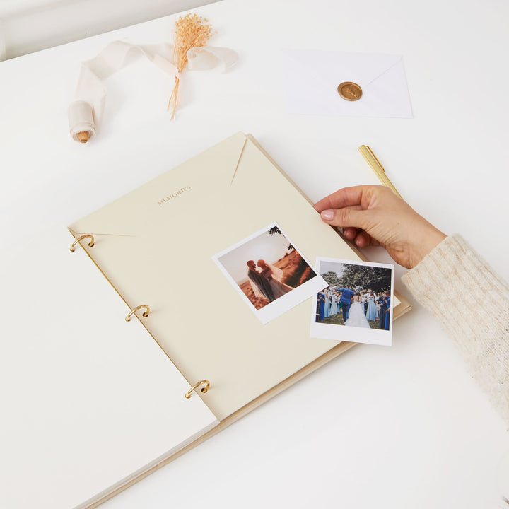 Minimalist wedding photo album with an ivory cloth cover, gold details, and ivory pages, perfect for preserving memories.