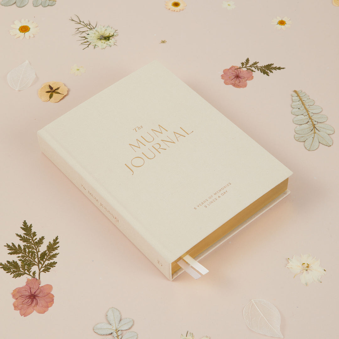 Flat lay of ivory cloth mum journal highlighting premium fabric cover and simple design