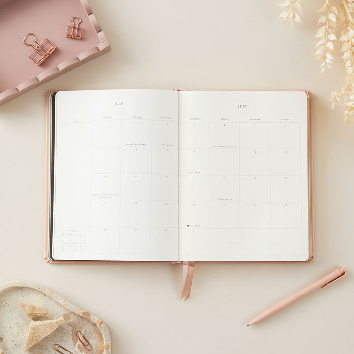 2025 planner in soft pink vegan leather with gold details, offering equal space for daily time-blocking, to-do lists, and sections for monthly goals and budget tracking.