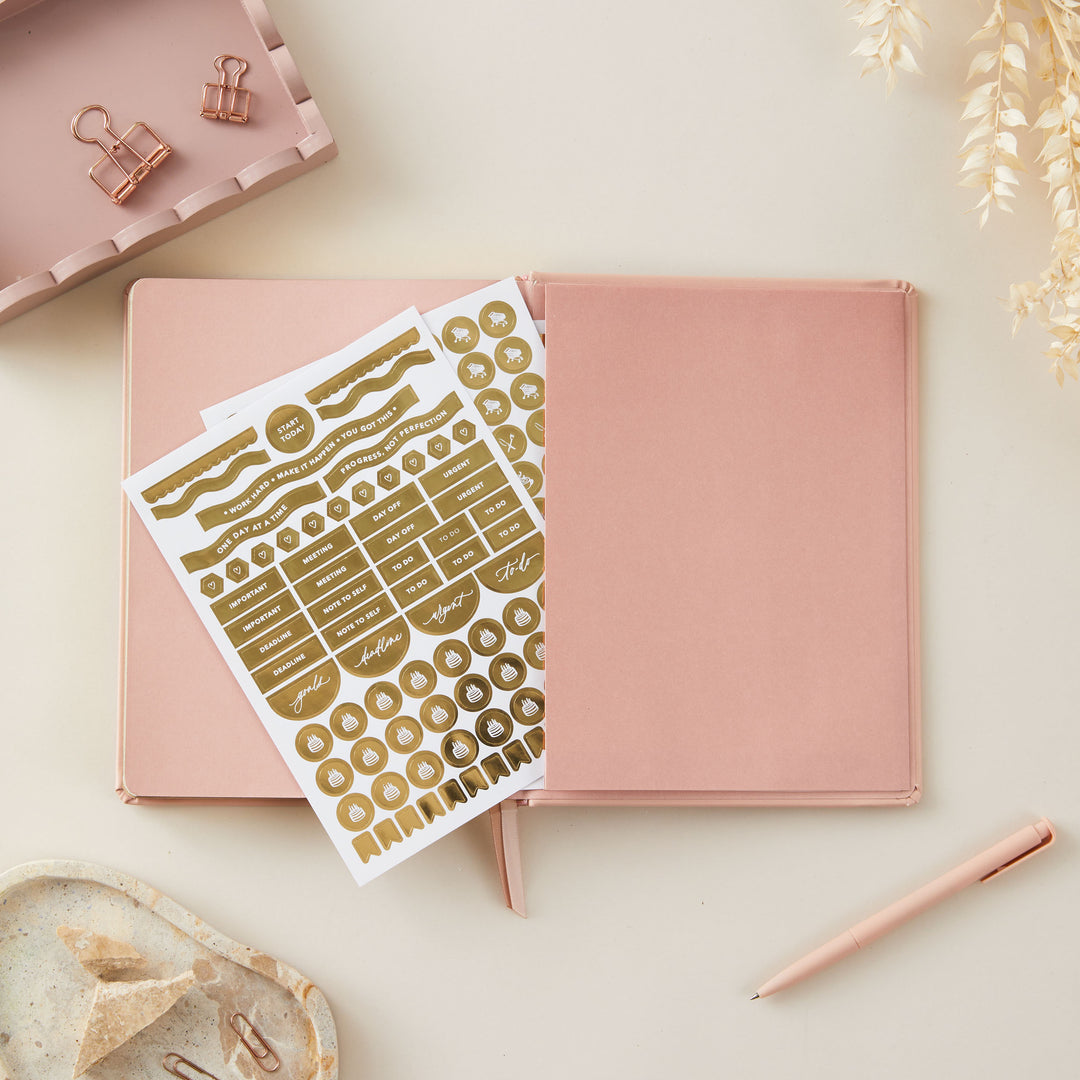 Soft pink vegan leather 2025 weekly planner with gold accents, offering equal space for daily time-blocking, to-do lists, notes, and monthly goals and budgeting.