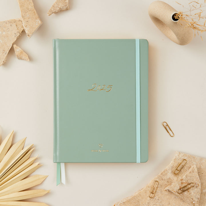 2025 weekly planner with a sage green vegan leather cover and gold details, featuring time-blocking with equal space for each day, to-do lists, notes, and monthly goals and budget pages.