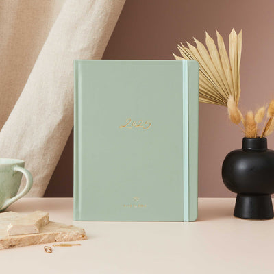 Sage green vegan leather 2025 planner with gold accents, offering equal space for daily time-blocking, to-do lists, notes, and monthly goals and budgeting.