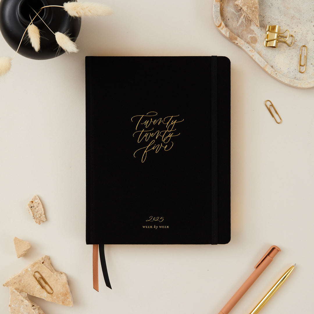 A beautiful and practical 2025 diary with an elegant design, open to display its organized pages and sleek layout.
