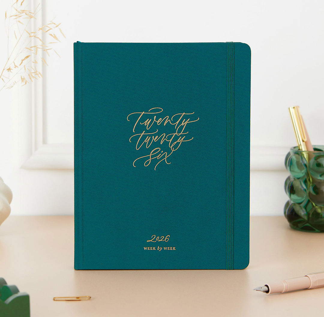 Dark green planner with '2026' on a light surface