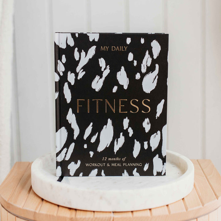 Exercise log and nutrition tracker open on wooden desk