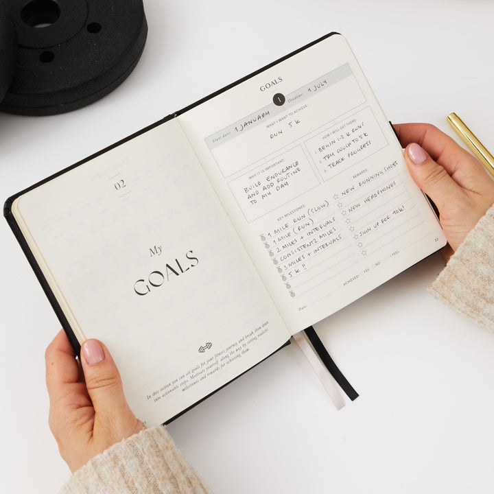 Compact black progress journal for tracking sets and reps