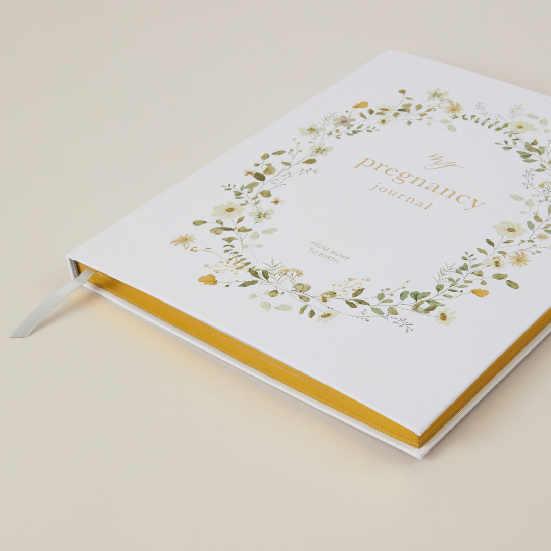 Pregnancy journal with floral design on a beige background