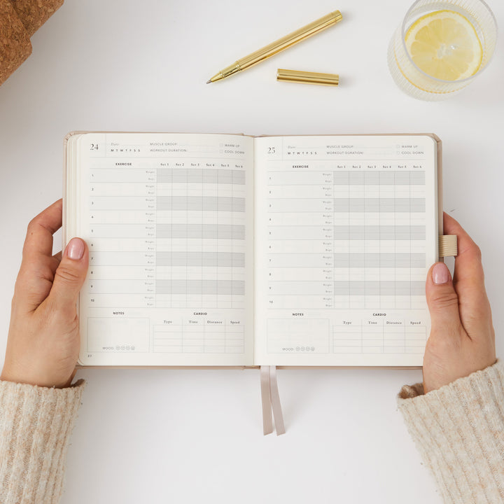 Beige fitness journal for tracking sets, reps, and measurements