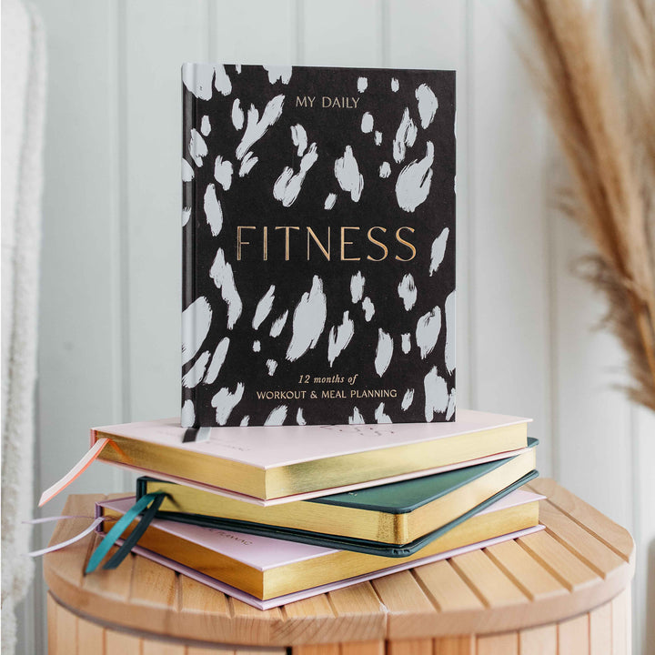 Flat lay of training logbook surrounded by healthy food