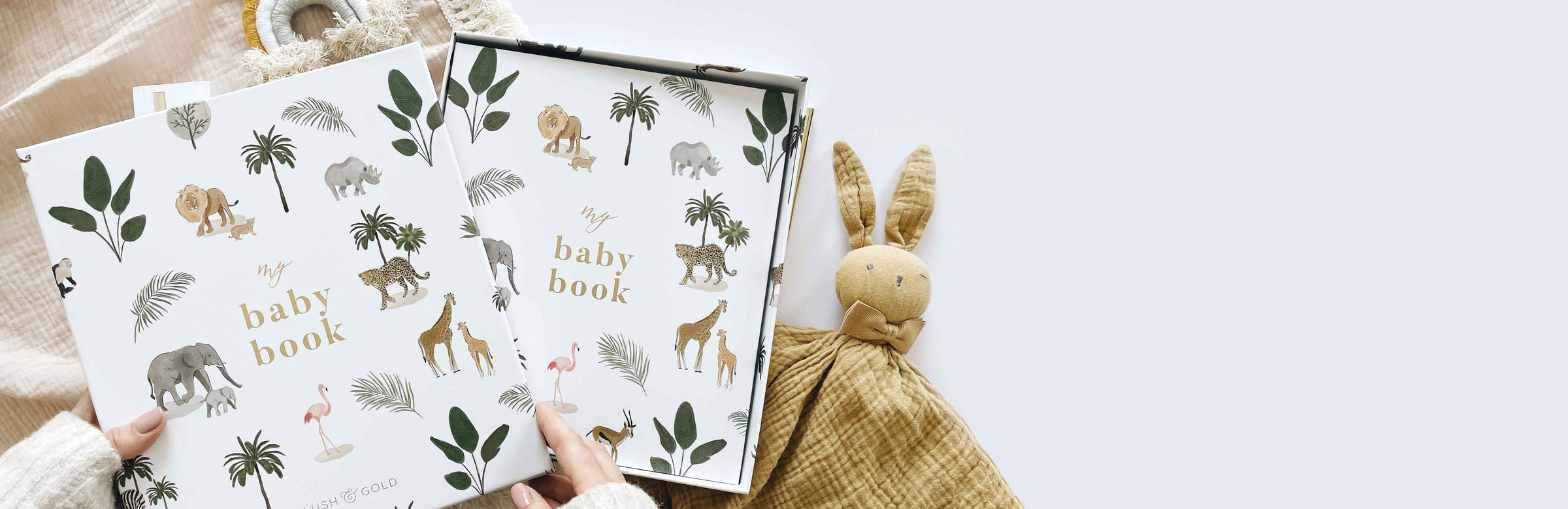 Two baby books with animal illustrations on a white surface with a plush toy.