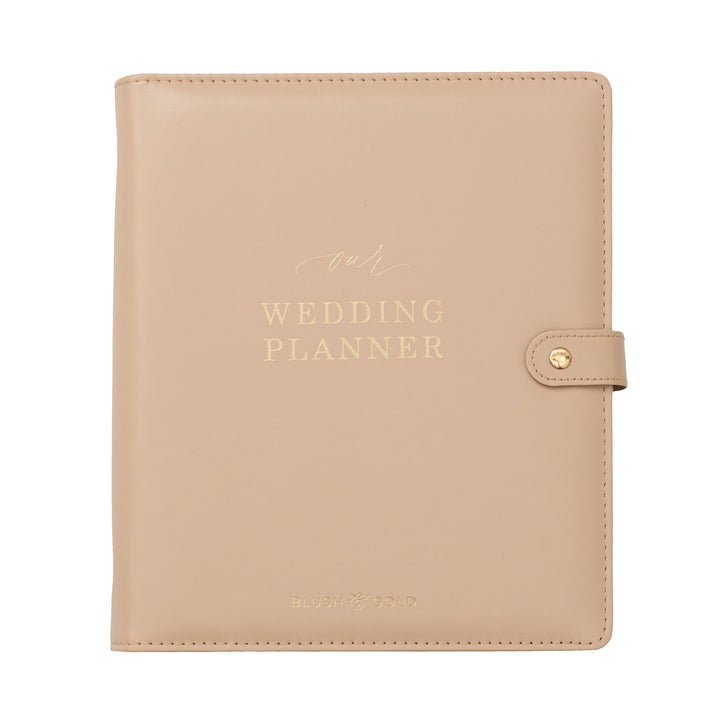 Flat lay product shot of a nude leather wedding planner binder with gold foil lettering and snap closure on a white background