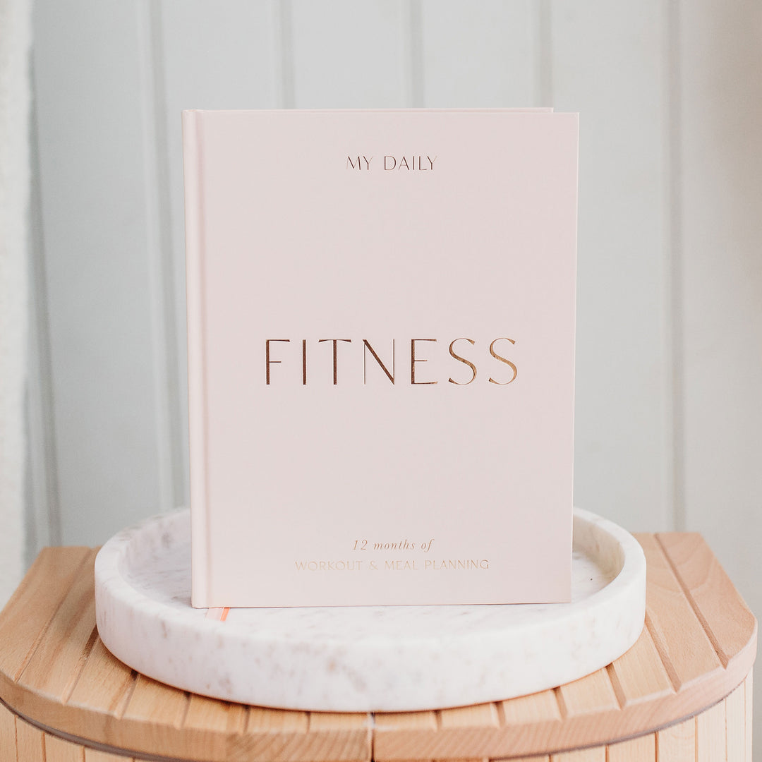 Open Fitness Log Book showing daily workout and meal entries.