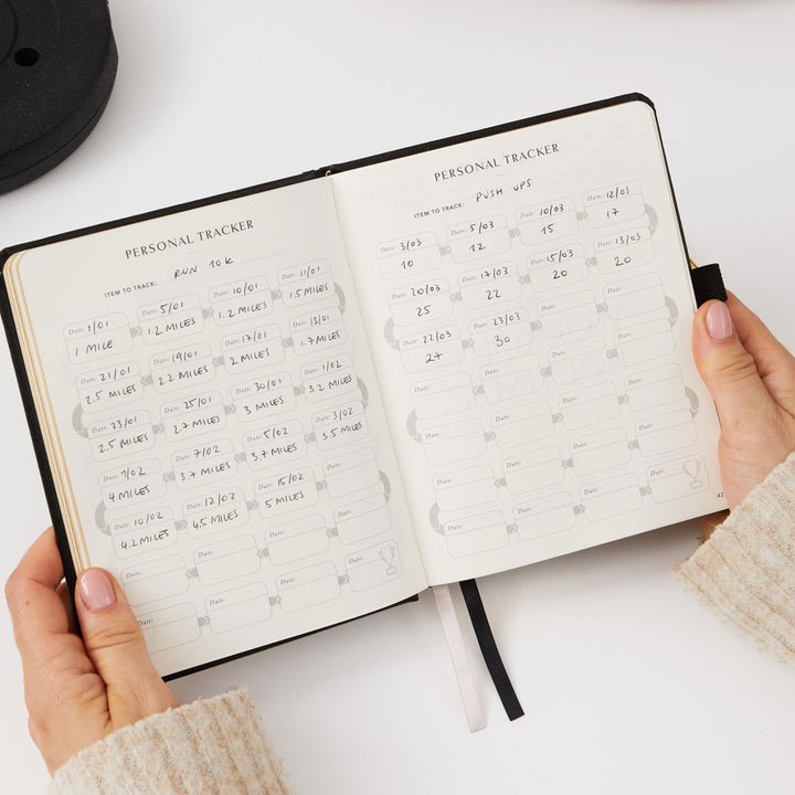 Black fitness journal with progress trackers