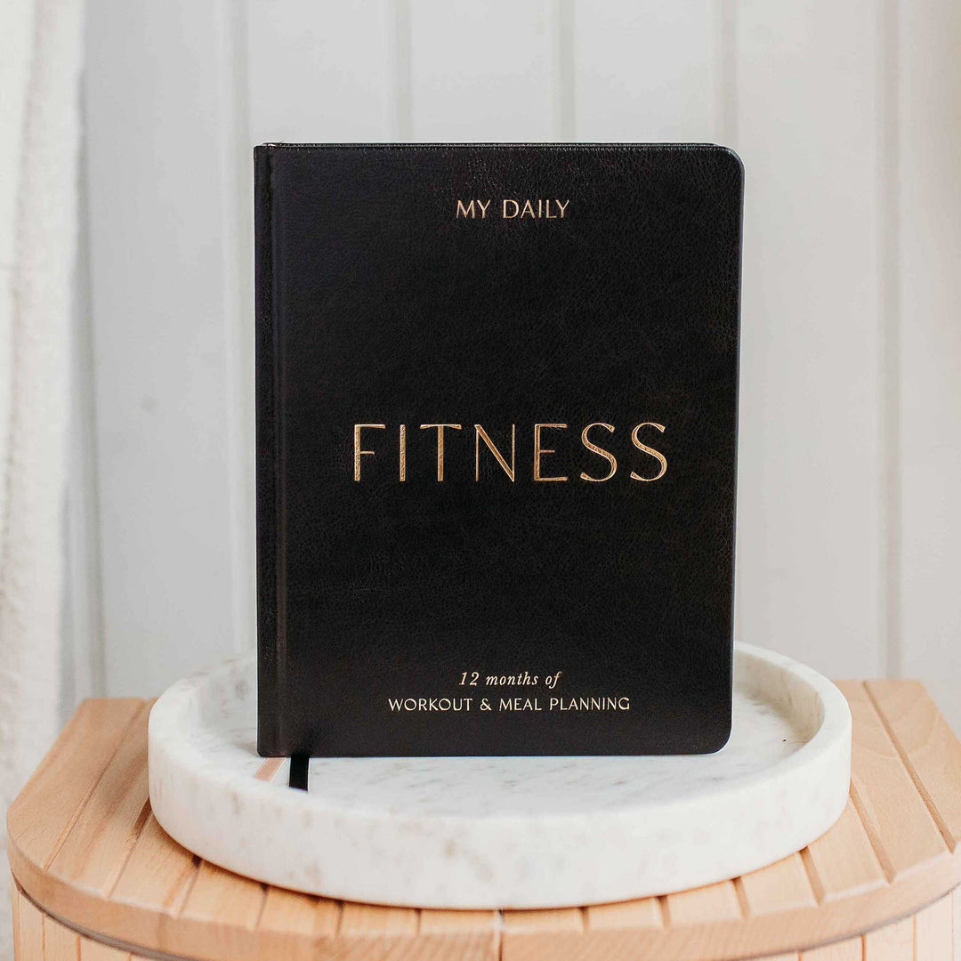 Training logbook open on a desk with gym accessories