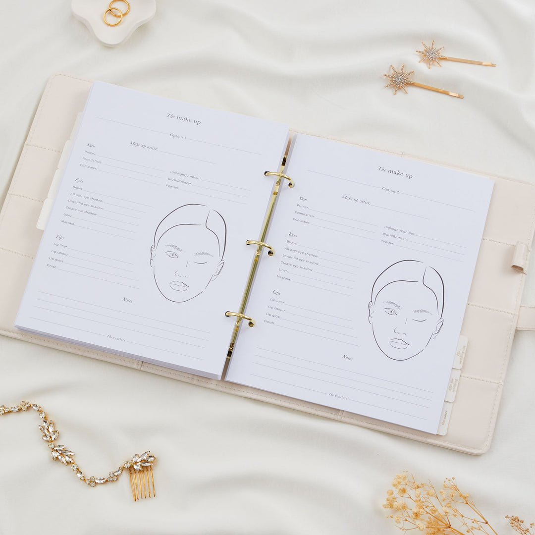 Open wedding planner binder showing two bridal makeup planning pages with face chart illustrations and product fields