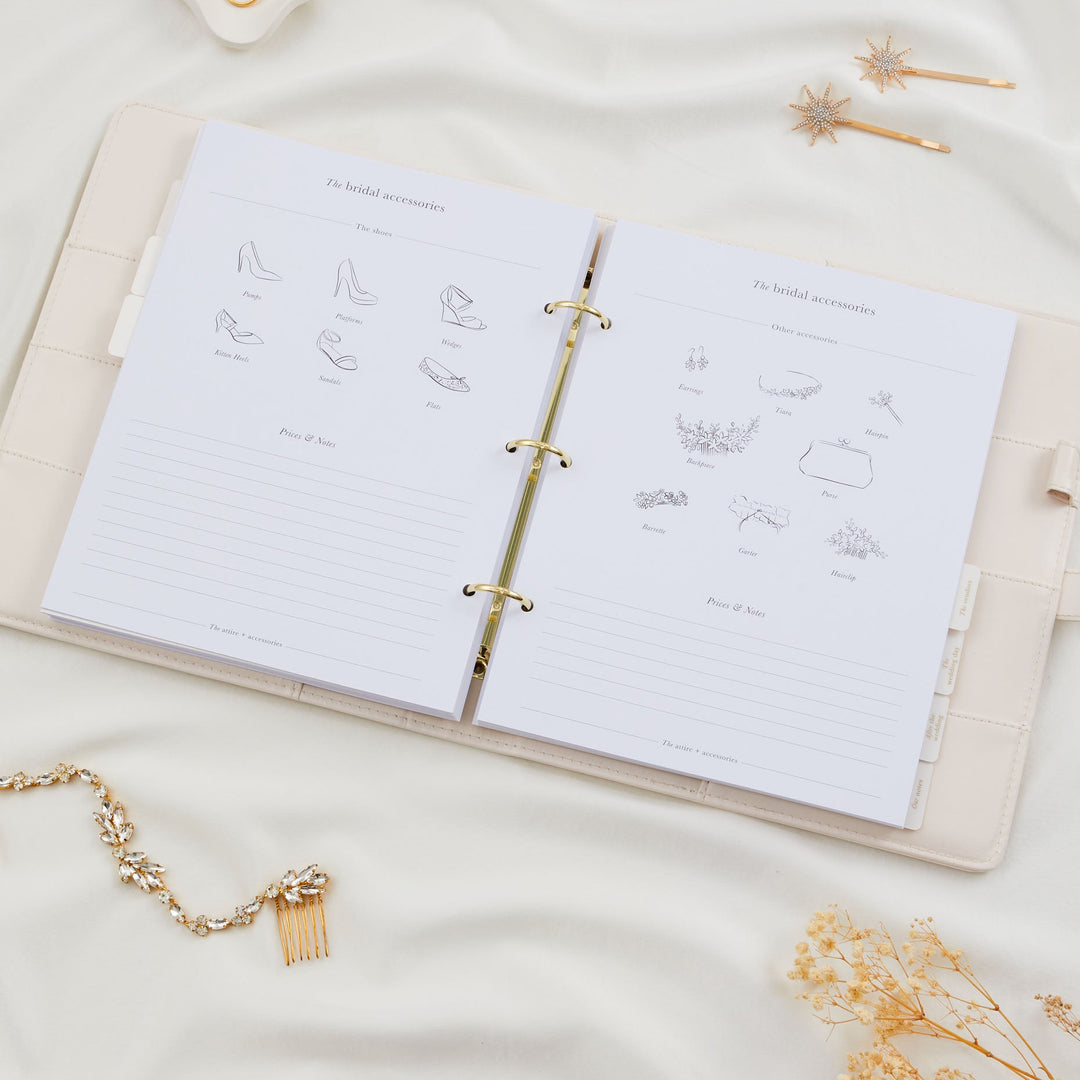 Open wedding planner binder showing bridal accessories pages with illustrated shoe styles and other accessory categories including earrings, tiara and bouquet