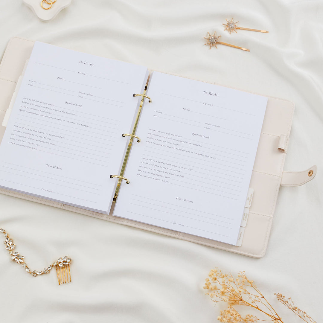 Open wedding planner binder showing two florist comparison pages with questions to ask and prices and notes sections