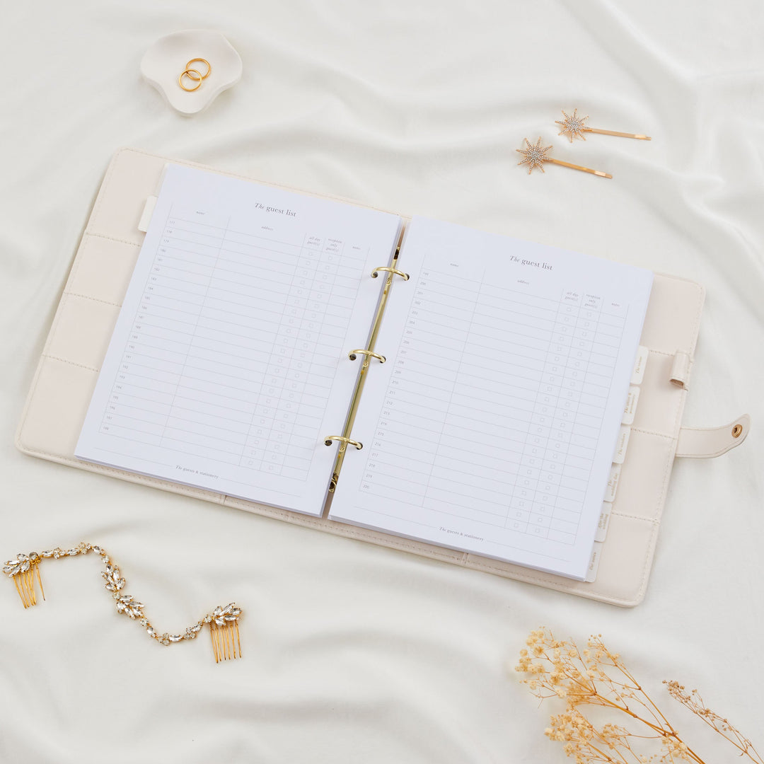 Open wedding planner binder showing a double page guest list spread with numbered rows for names, addresses and day or evening guest columns