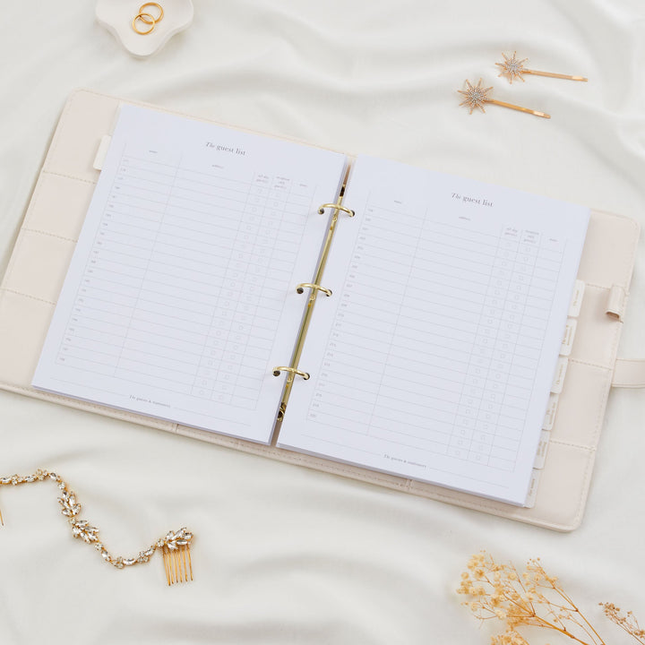 Open wedding planner binder showing double page guest list spread with numbered rows for names and addresses